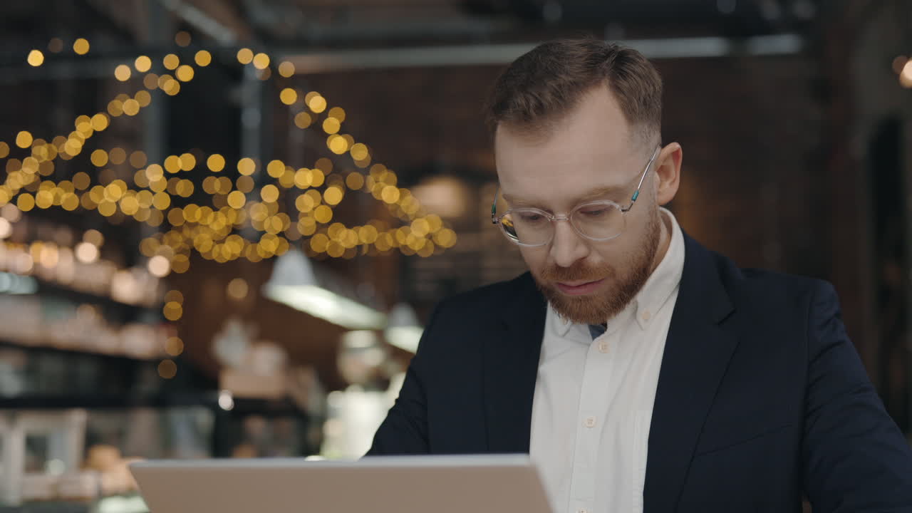 бизнесмен, работающий на ноутбуке в кафе