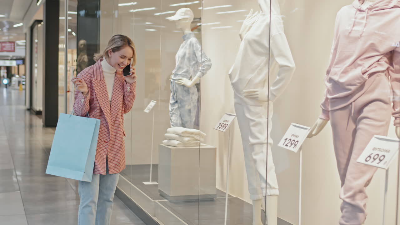 Beautiful Woman Having Phone Call Near Window Display In Shopping Mall