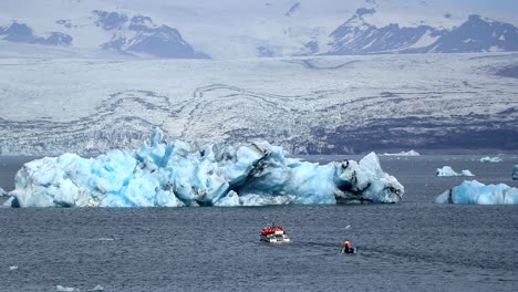 pequeños barcos de turismo se acercan a un gran iceberg