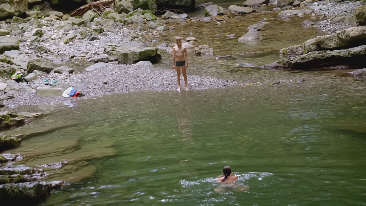 산의 하천 에서 수영 하는 아이 들