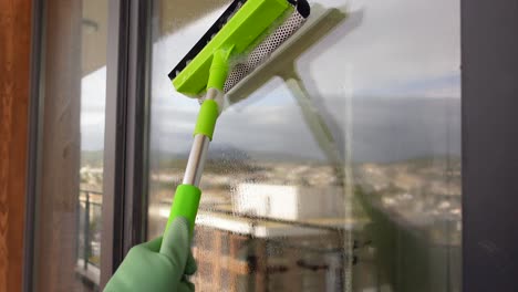 person cleaning a window with a squeegee