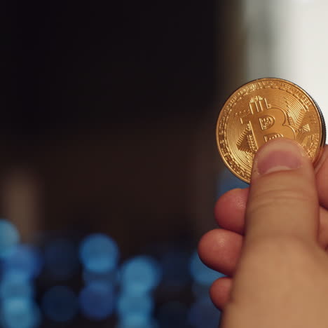 Golden Bitcoin in a man hand. Concept of mining. Electronic virtual money. Symbol of investment in cryptocurrency.