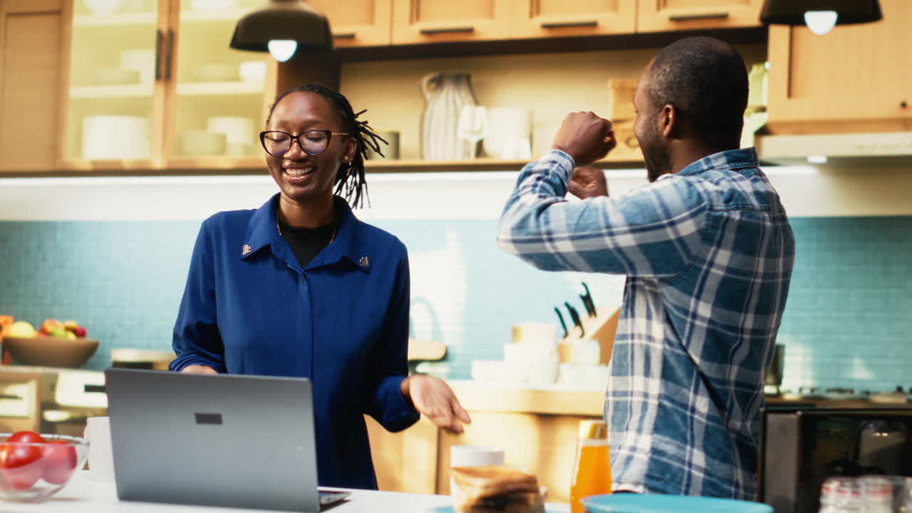 Couple Dancing in Kitchen with Laptop