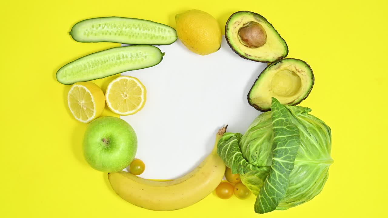 espacio de copia de papel en fondo amarillo con frutas y verduras verdes. concepto de alimentos saludables. dejar de moverse plana