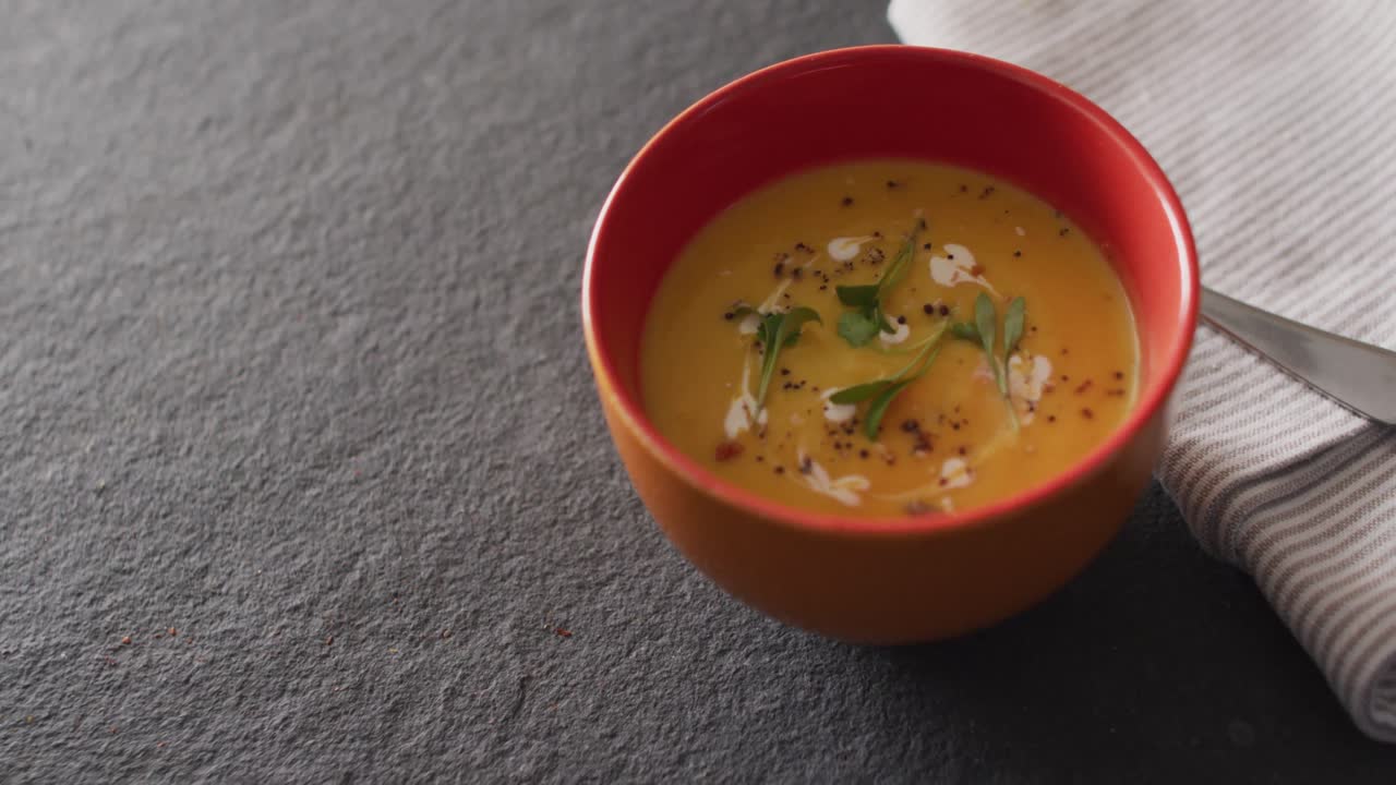 video de sopa de verduras de crema en un tazón en la mesa gris