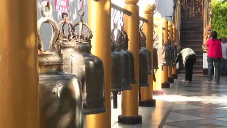 people look at gold urns for sale in a marketplace