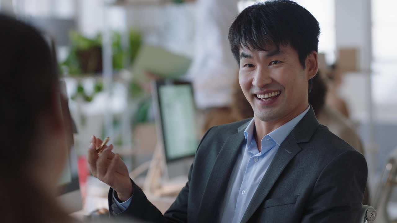 전문적인 아시아 사업가 인턴과 채팅하고 면접에 대해 논의하고 사무실에서 대화를 나누고 팀워크를 즐기고 있습니다.