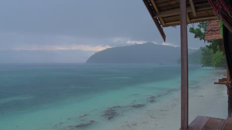 El-Aguacero-Tropical-Desde-El-Mirador-De-Una-Cabaña-En-La-Isla-De-Kri-En-El-Archipiélago-De-Raja-Ampat,-Contemplando-El-Vasto-Mar-Mientras-La-Lluvia-Cae-En-Cascada-Desde-El-Cielo