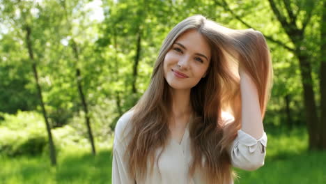 portrait of a smiling young woman in a green park