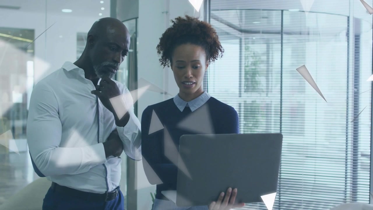 Donna con laptop che indica, facendo inclinare un uomo, mentre esaminano affari insieme e triangoli fluttuano
