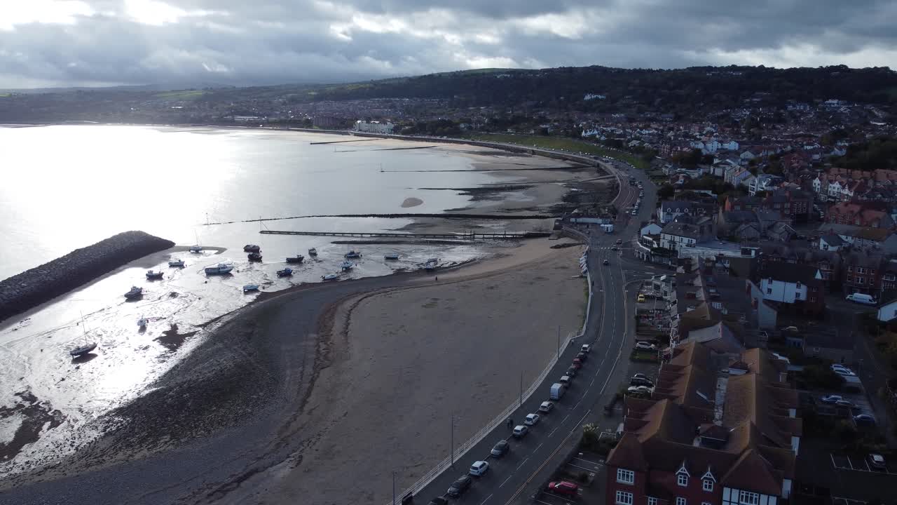 North Wales seaside town coastline hotels harbour breakwater aerial view orbit right
