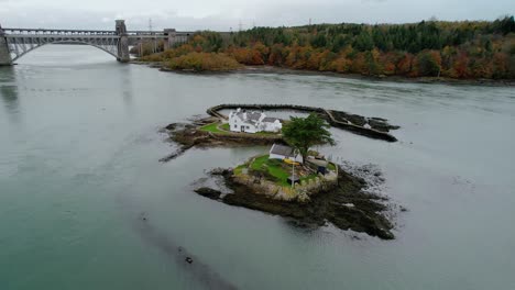 Vista-Aérea-Ynys-Corneado-Goch-Casas-En-La-Isla-Whitebait-Galés-Que-Fluye-Estrecho-De-Menai-Anglesey-órbita-Izquierda