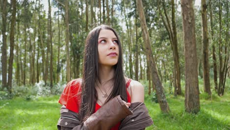 bastante joven latina, mujer morena de pie en un bosque y disfrutando de la naturaleza