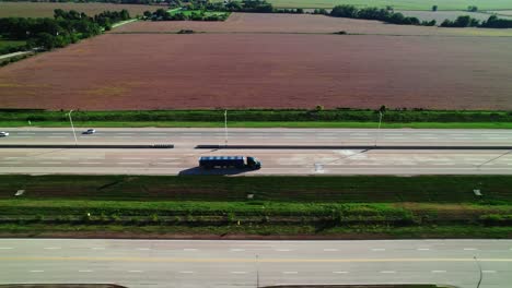 tracking-aerial-of-a-black-Conestoga---flatbed-Semi-Trailer-Truck-driver-driving-on-interstate