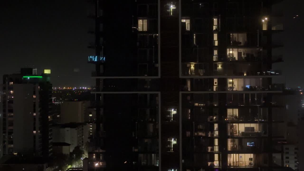 東パースの都市のアパートの夜景、窓から漏れる光のミディアムクローズアップ。