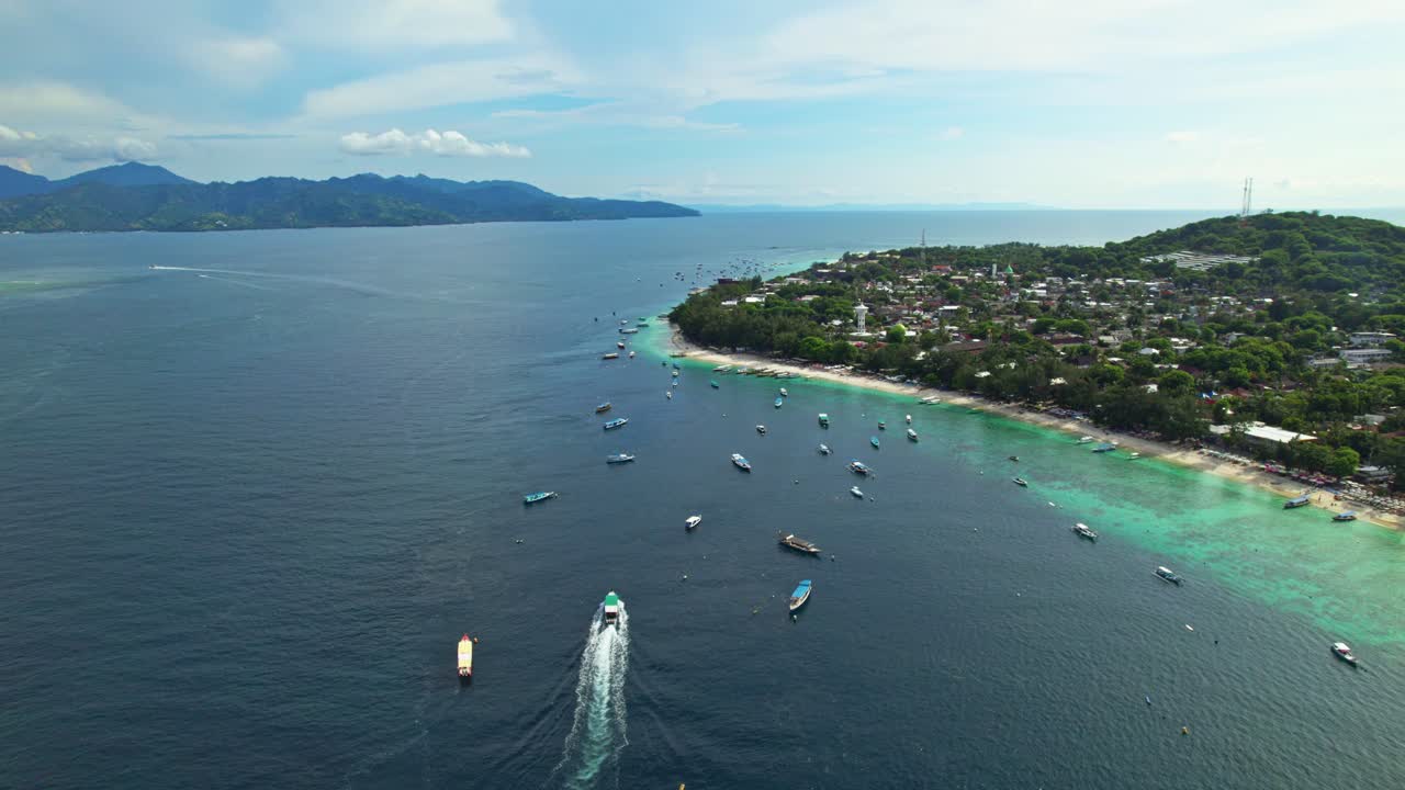 Aerial orbit tourist boat cruising into Tropical island, Gili Trawangan