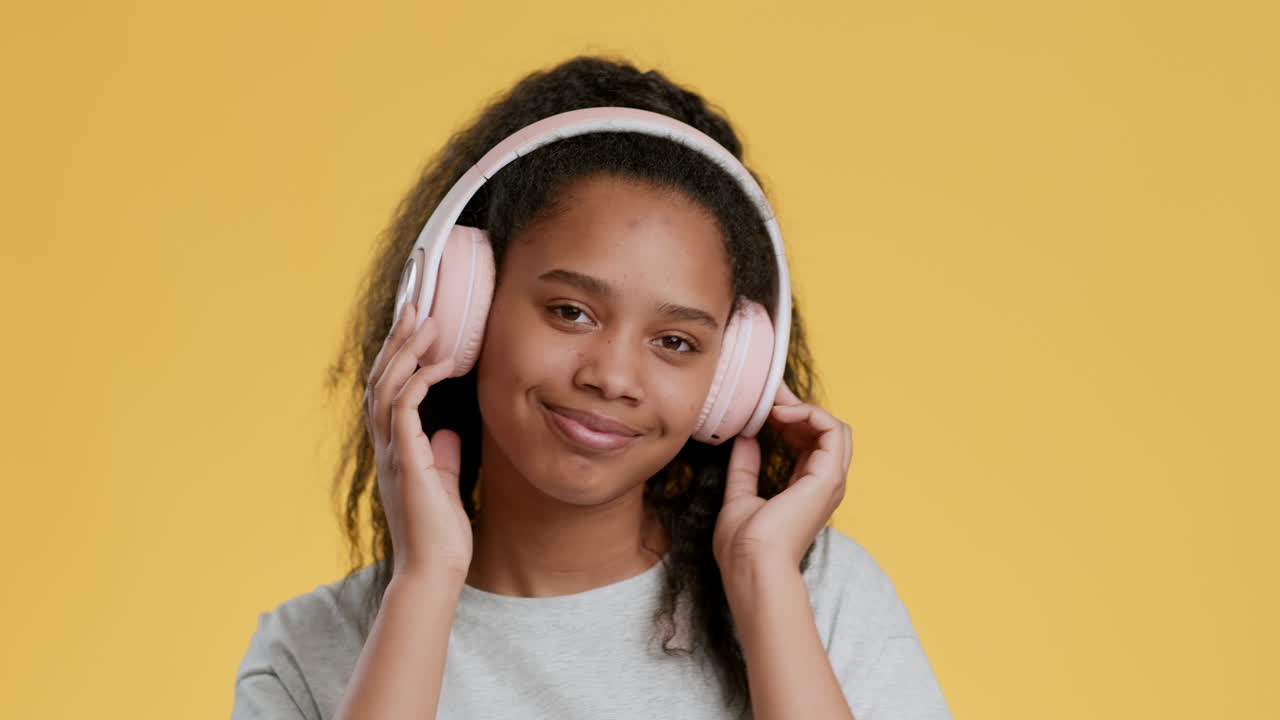 Ragazza adolescente che ascolta musica con cuffie rosa
