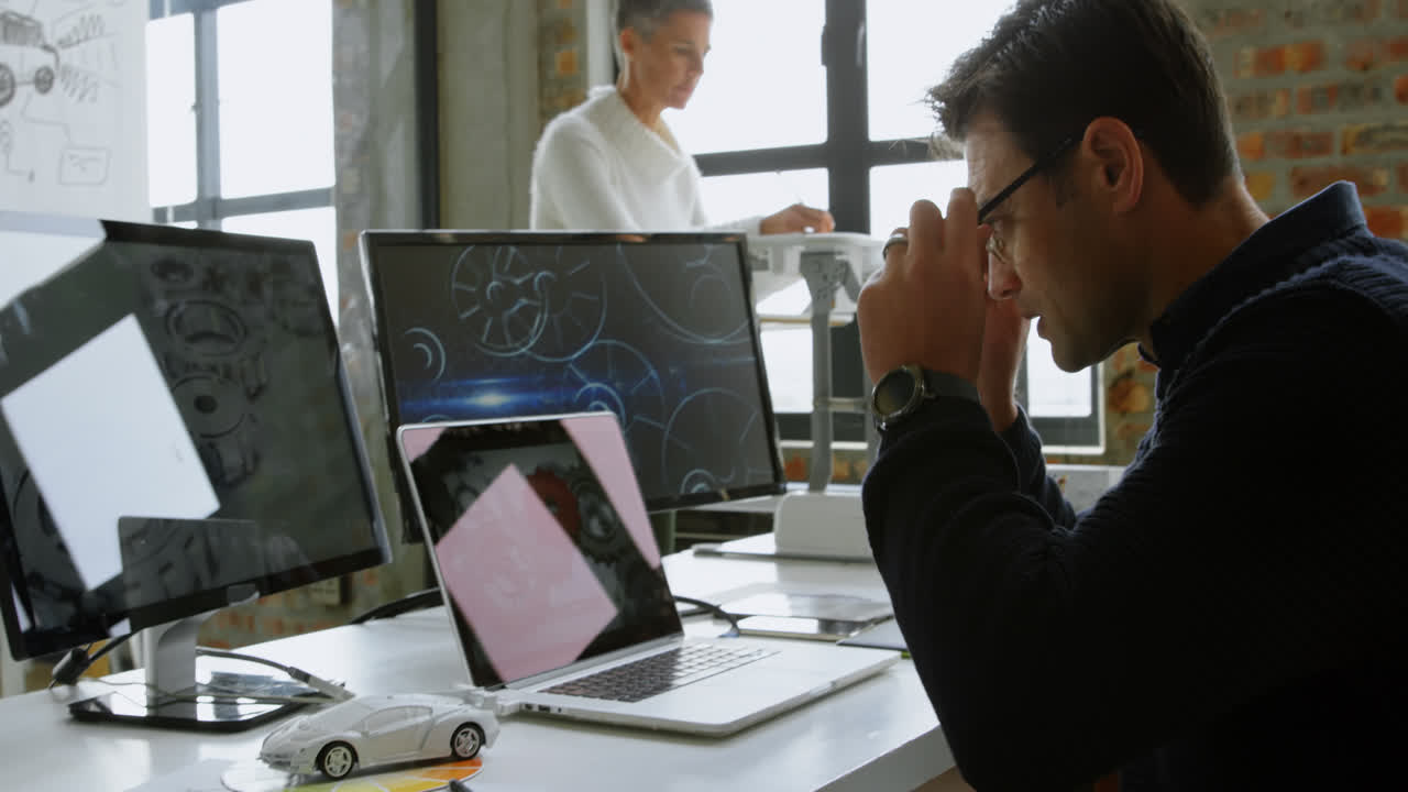 Car designer using laptop at desk 4k