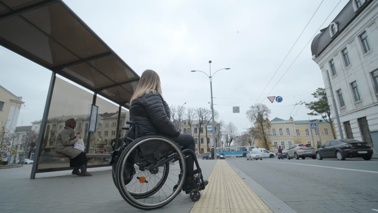 mujer en silla de ruedas esperando un autobús en una parada de autobús