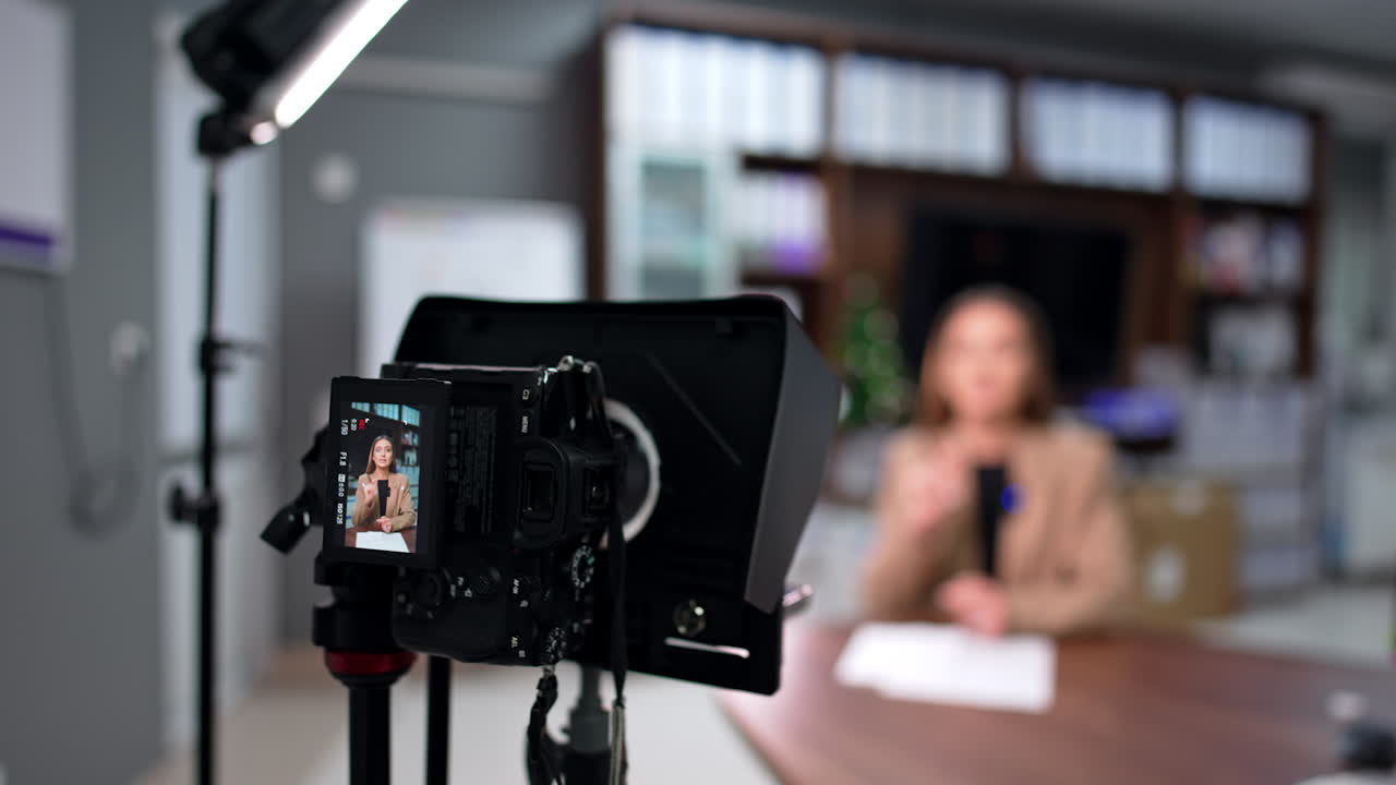 Tripod with a professional camera recording a female speech. Close up. Blog creation. Blurred backdrop.
