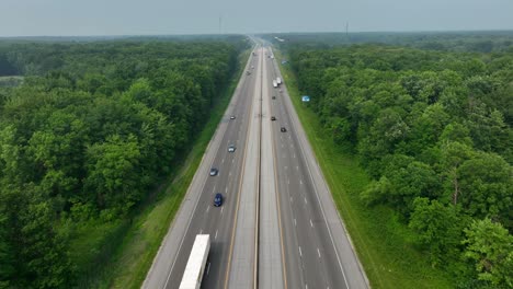 Dolly-Aéreo-Hacia-Adelante-Sobre-Una-Autopista-De-6-Carriles-En-Bosques-En-EE.UU.