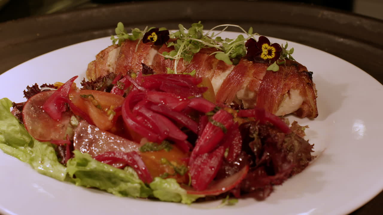 신선한  ⁇ 러드와 함께  ⁇ 고기 베이컨 접시가 레스토랑에서 아름답게 선보여 즐겁고 맛있는 식사 경험을 제공합니다.