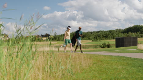 caucasian woman and african american man meeting on the golf course.