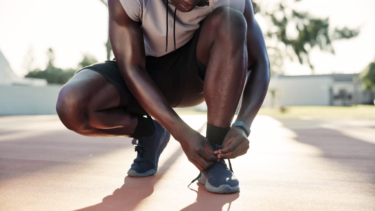 A man tying his shoelace before running