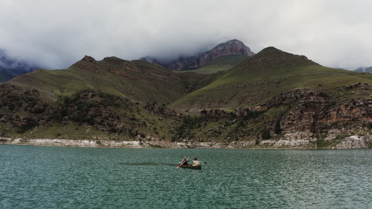 una pareja en canoa en un lago de montaña
