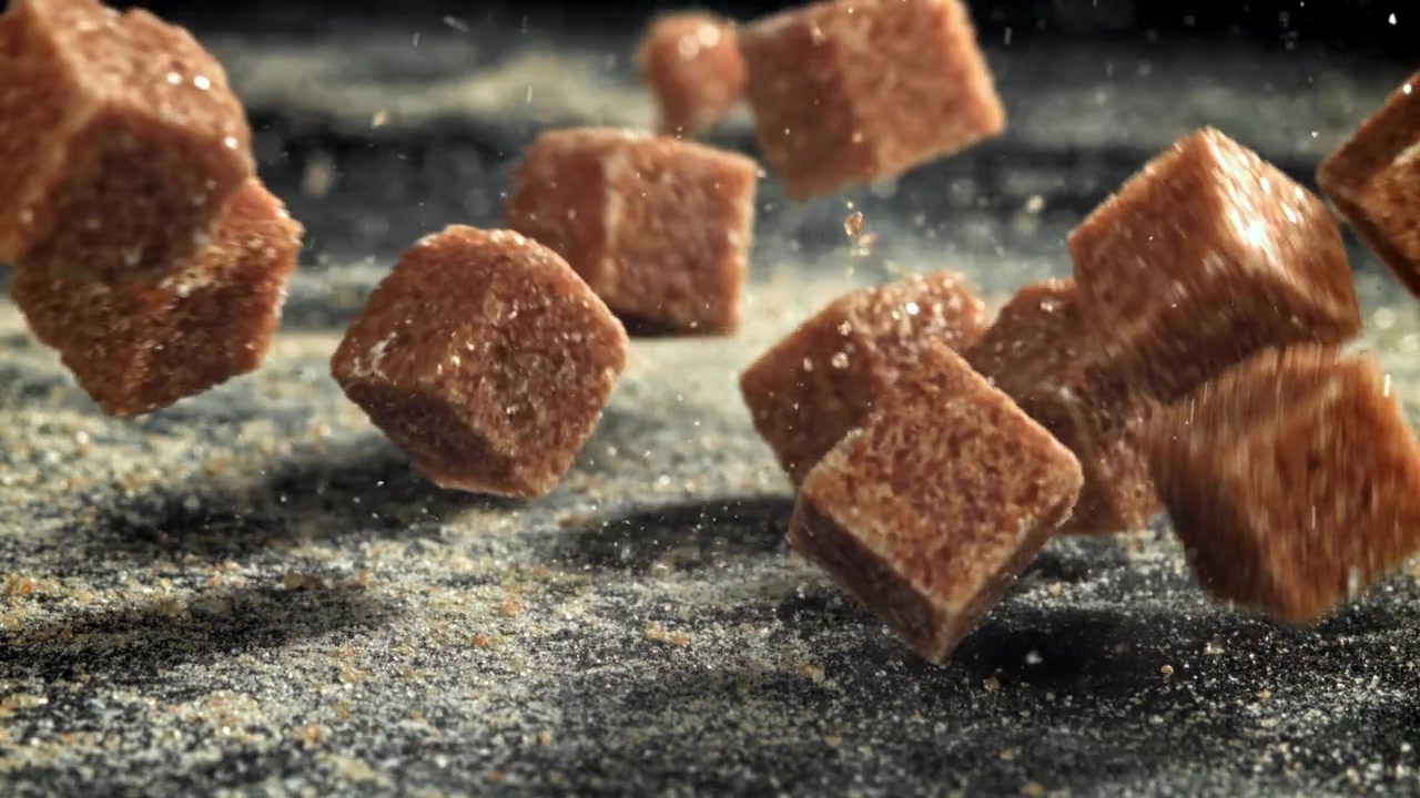 Slow Motion Brown Sugar Cubes Falling on Dark Background
