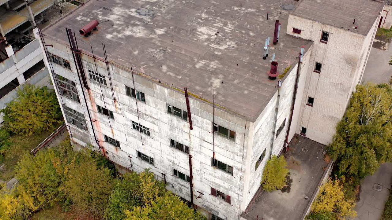 Old factory. Abandoned buildings and warehouses with broken windows after the war. Empty industrial plant. View from above.