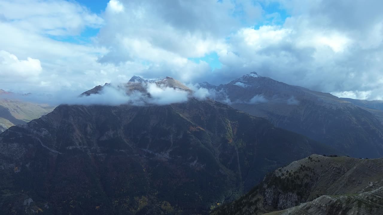 Majestic view of Collarada and La Moleta mountains under scattered clouds in Aragón Spain
