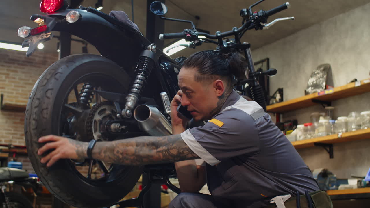 Repairman Calling Colleague to Ask about Fixing Motorbike Breakdown