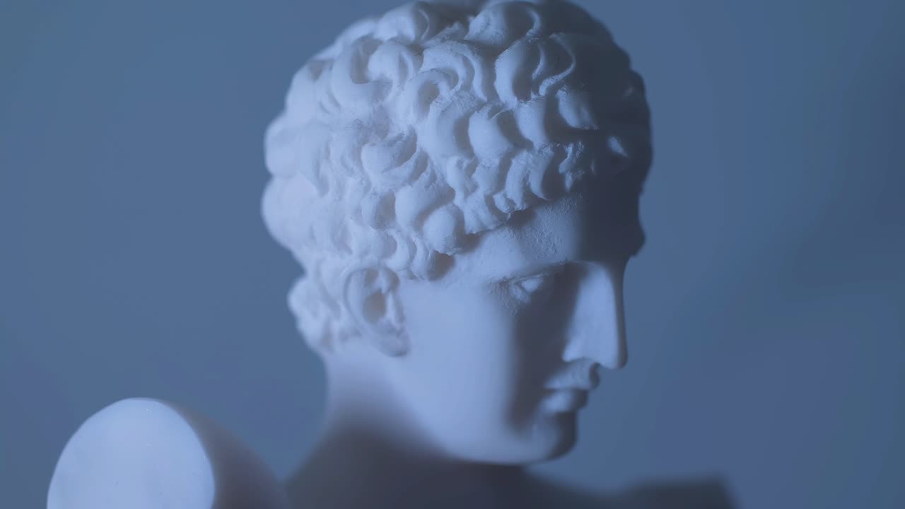 Statua rotante del dio greco Apollo in luce calda.