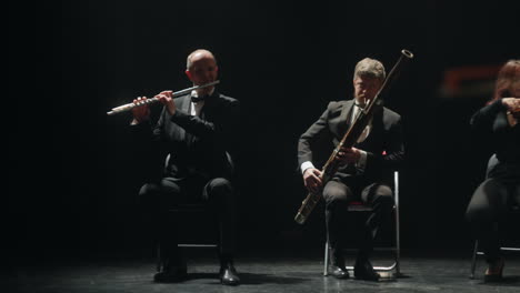 el fagotista y los flautistas están tocando música en la escena de la ópera dos músicos profesionales