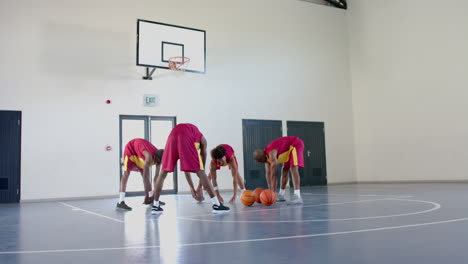 diverse basketball players practice in an indoor court