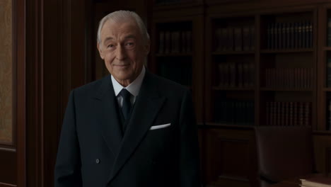 Portrait of an elegant older man in a suit standing in a library