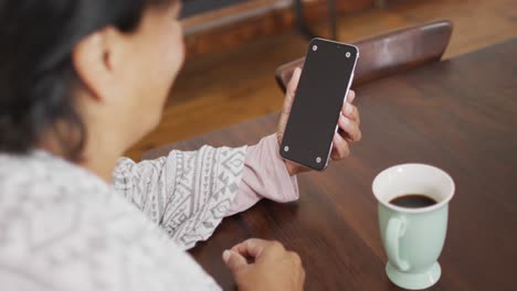 Afroamerikanische-Seniorin-Hält-Zu-Hause-Ein-Smartphone-Mit-Kopierplatz