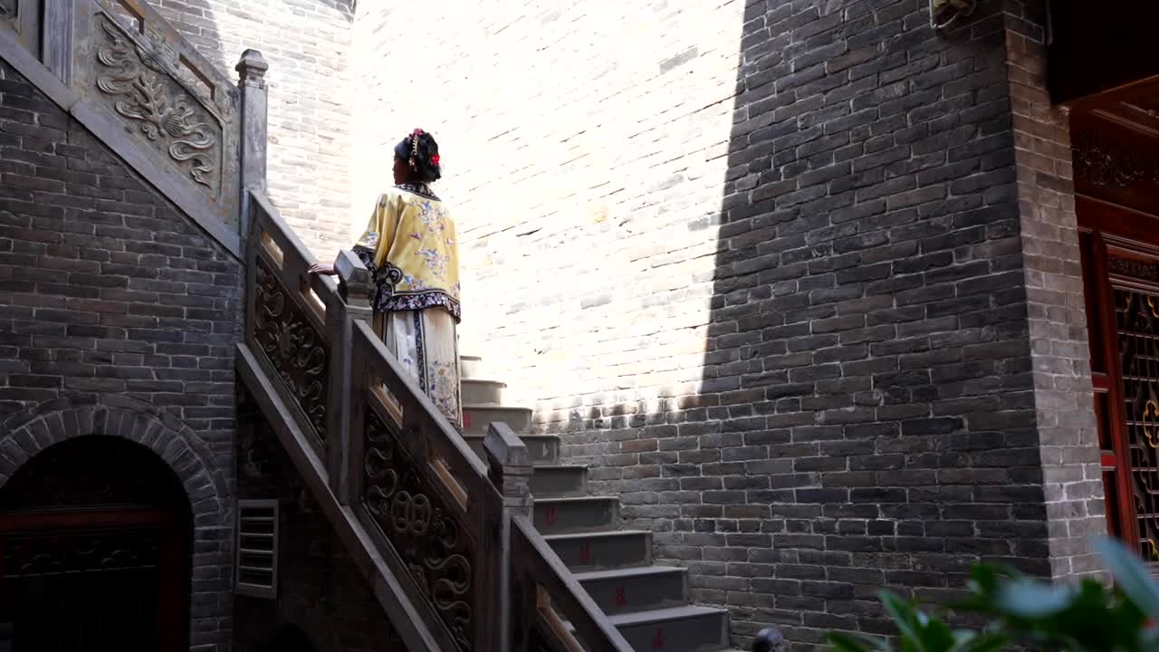 중국 핑야오 에서 실크 의 옷 을 입은 칭 왕조 의 여자 가 회색 계단 을 올라가고 있다