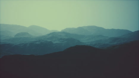 silhouette of swiss alps mountains in morning clouds