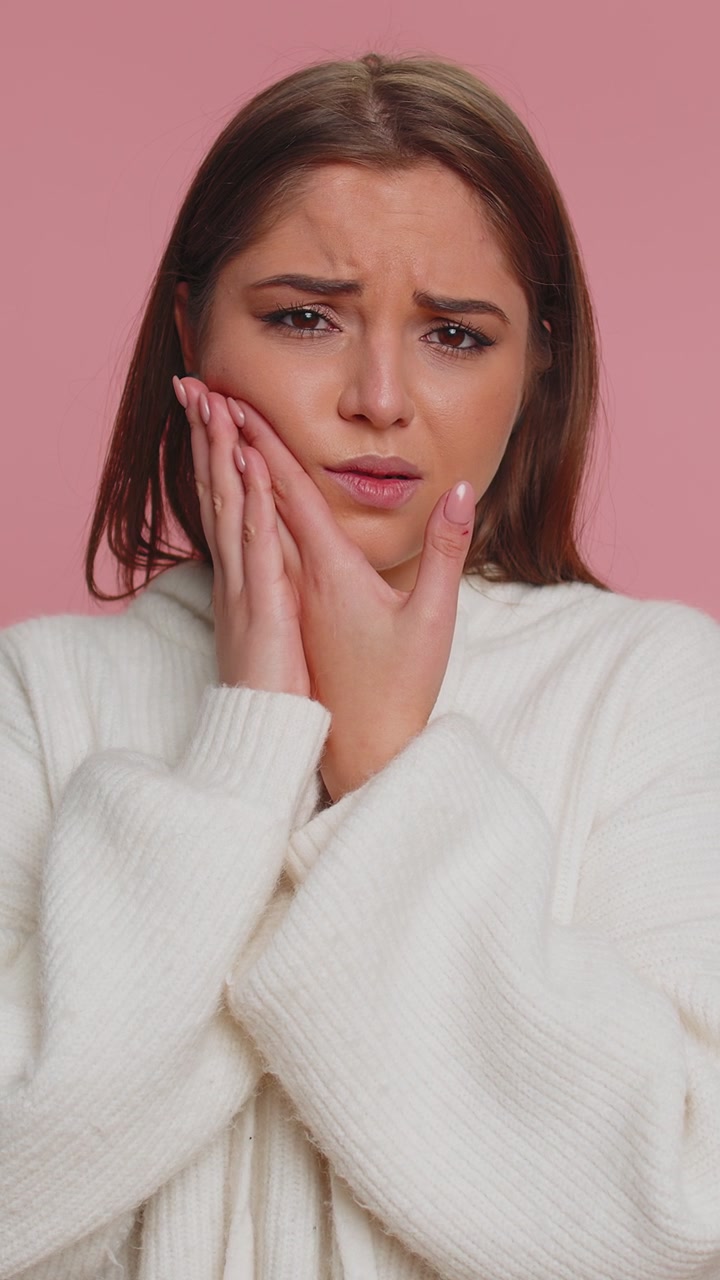 Woman touching cheek suffering from toothache cavities or gingivitis waiting for dentist appointment