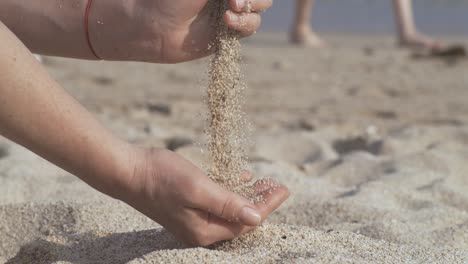 arena cayendo de la mano en cámara lenta en una playa. vacaciones y concepto de viaje. disparado en cámara súper cámara lenta 1000 fps.