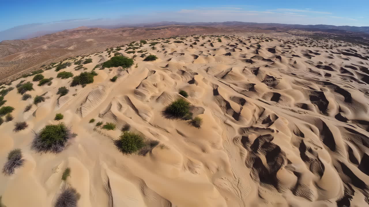 Aerial View of Vast Sand Dunes with Sparse Greenery