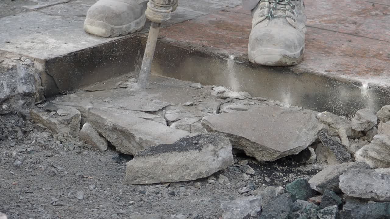 건축 노동자 가 잭햄러 를 사용 하여 콘크리트 를 부수고 있다