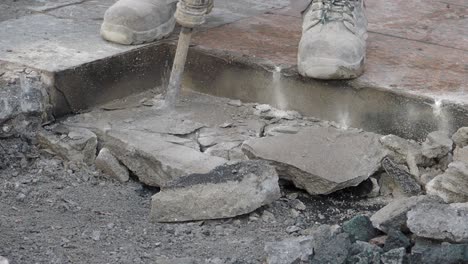 trabajador de la construcción rompiendo hormigón con un martillo