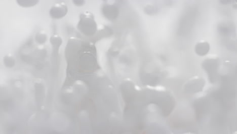 salpicaduras de leche en cámara lenta y macro-abstracto fluido blanco energéticamente rebotando hace gotas y salpicadures