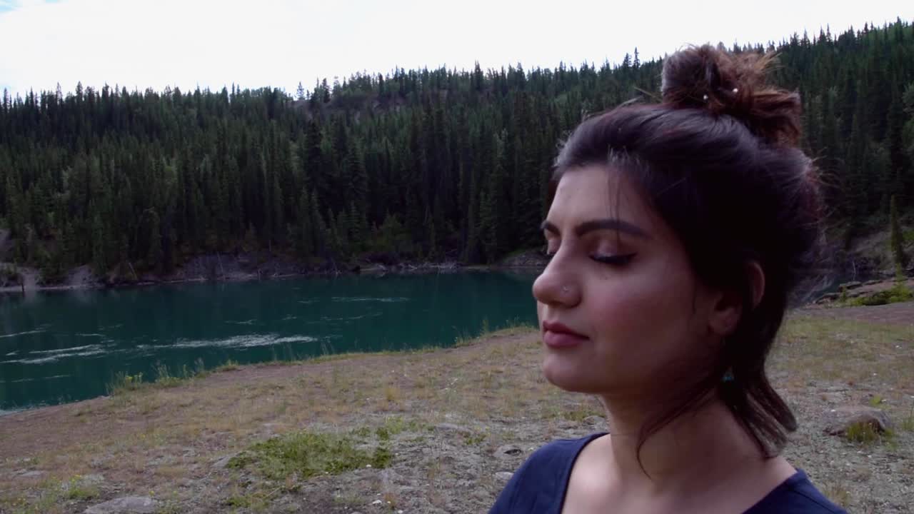 Indian woman meditates at Miles Canyon landscape, close up