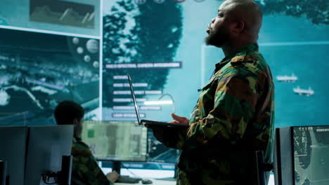 un equipo militar maneja las operaciones de ciberseguridad en un centro de control de alta tecnología.