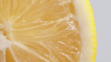 Slow-Motion-Macro-Shot-of-Flowing-Water-from-Lemon-Slice-on-white-Background