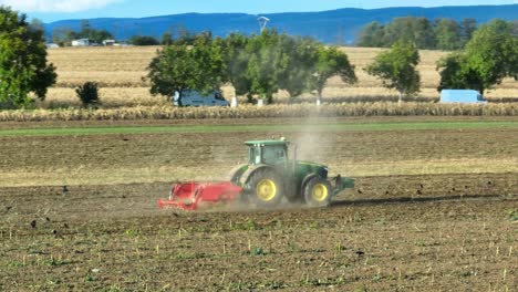 aerial view of tractor plowing farm field during